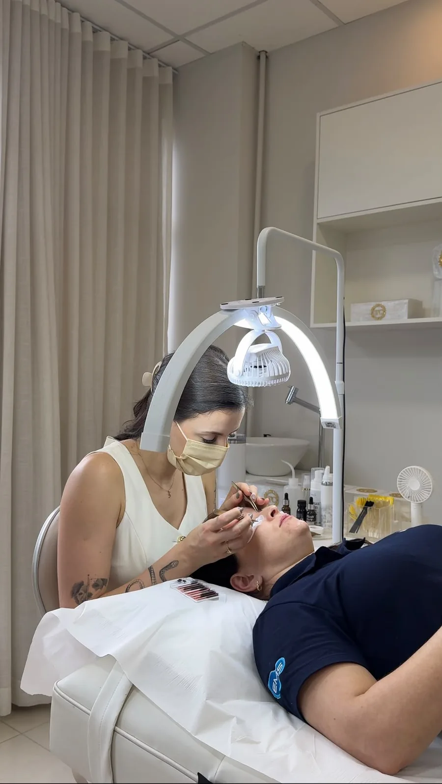 Thaís Colla aplicando extensão de cílios numa cliente no estúdio