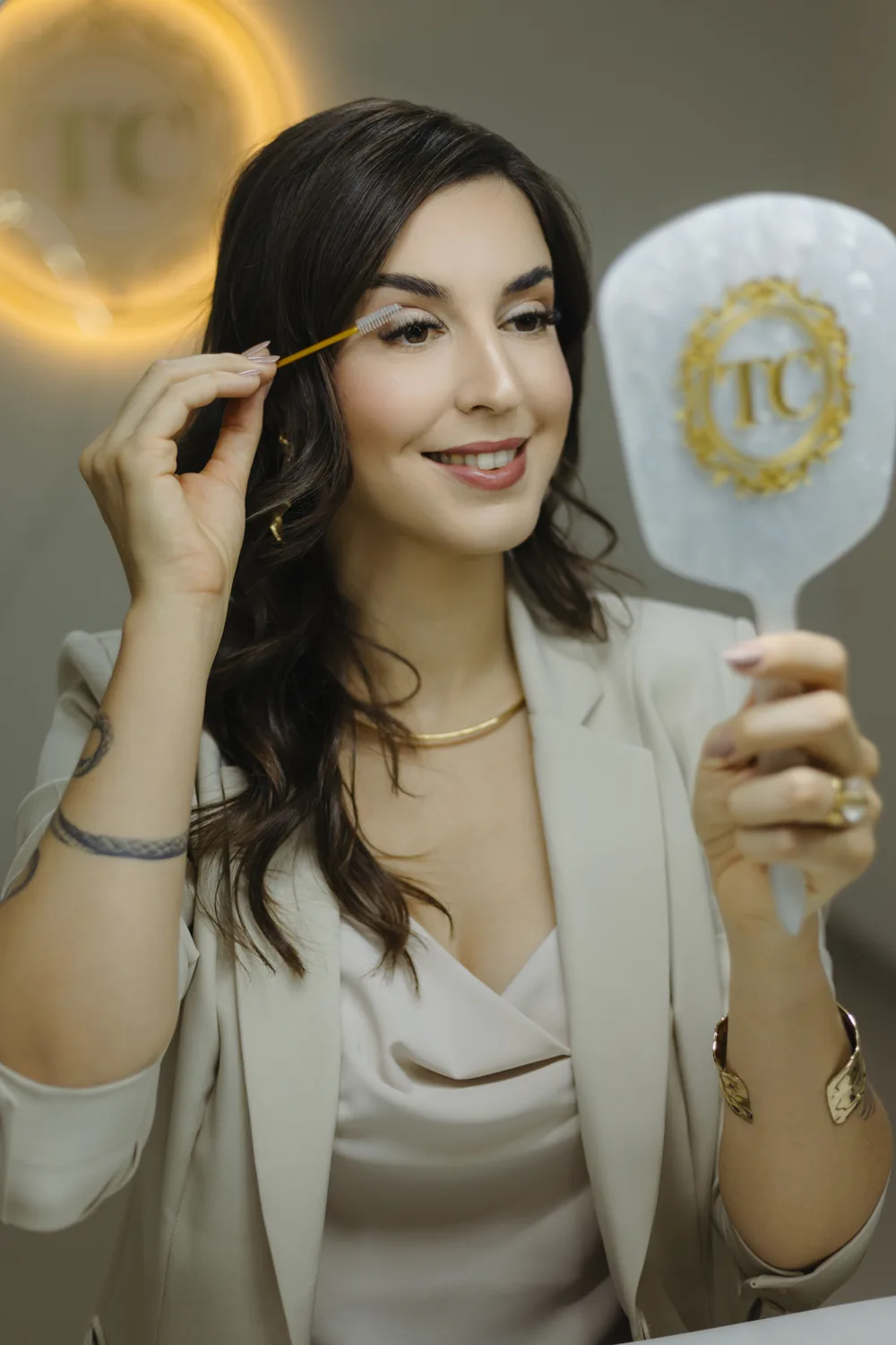 Thaís Colla segurando o espelho da marca durante o atendimento